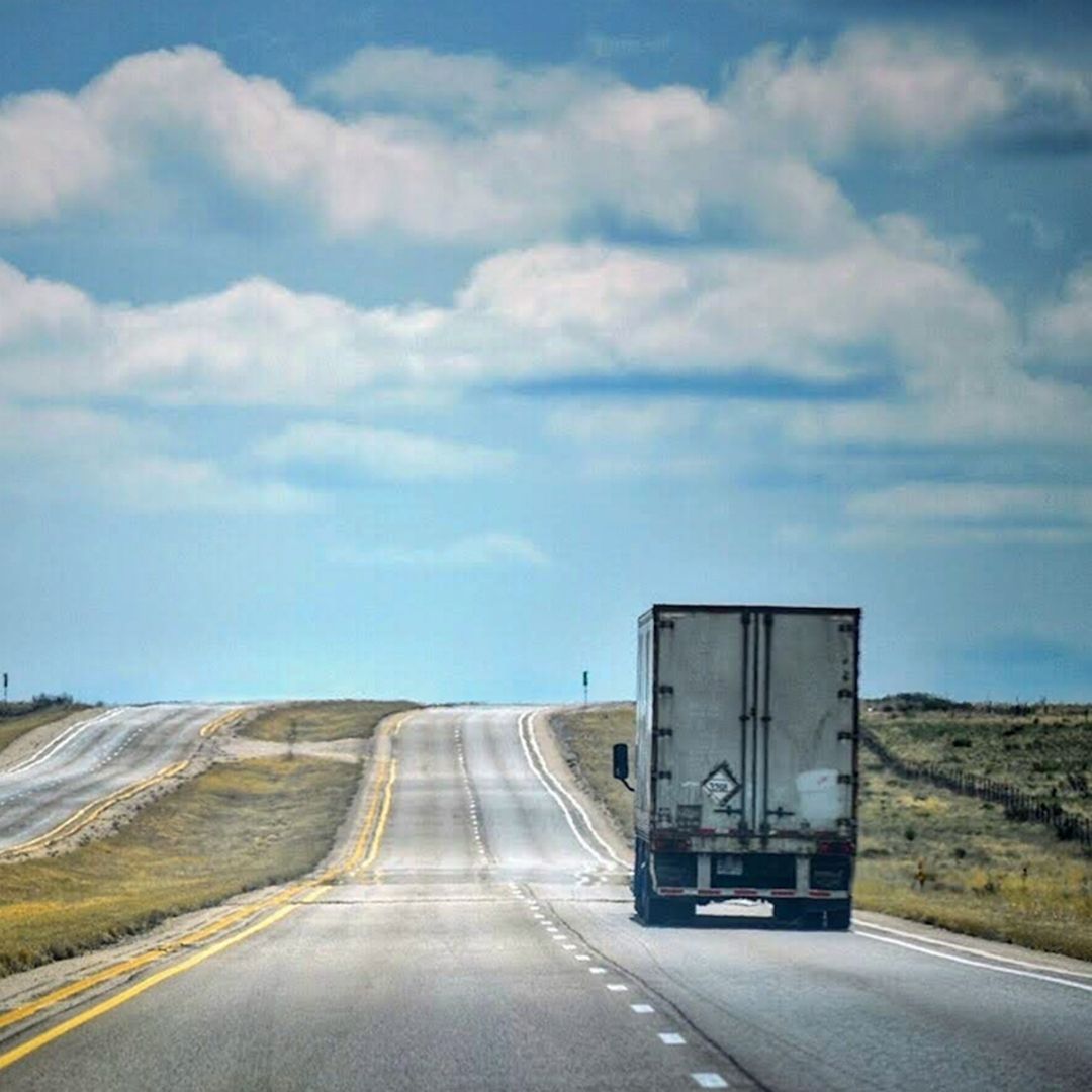 the rearview of a semi-truck driving on a highway