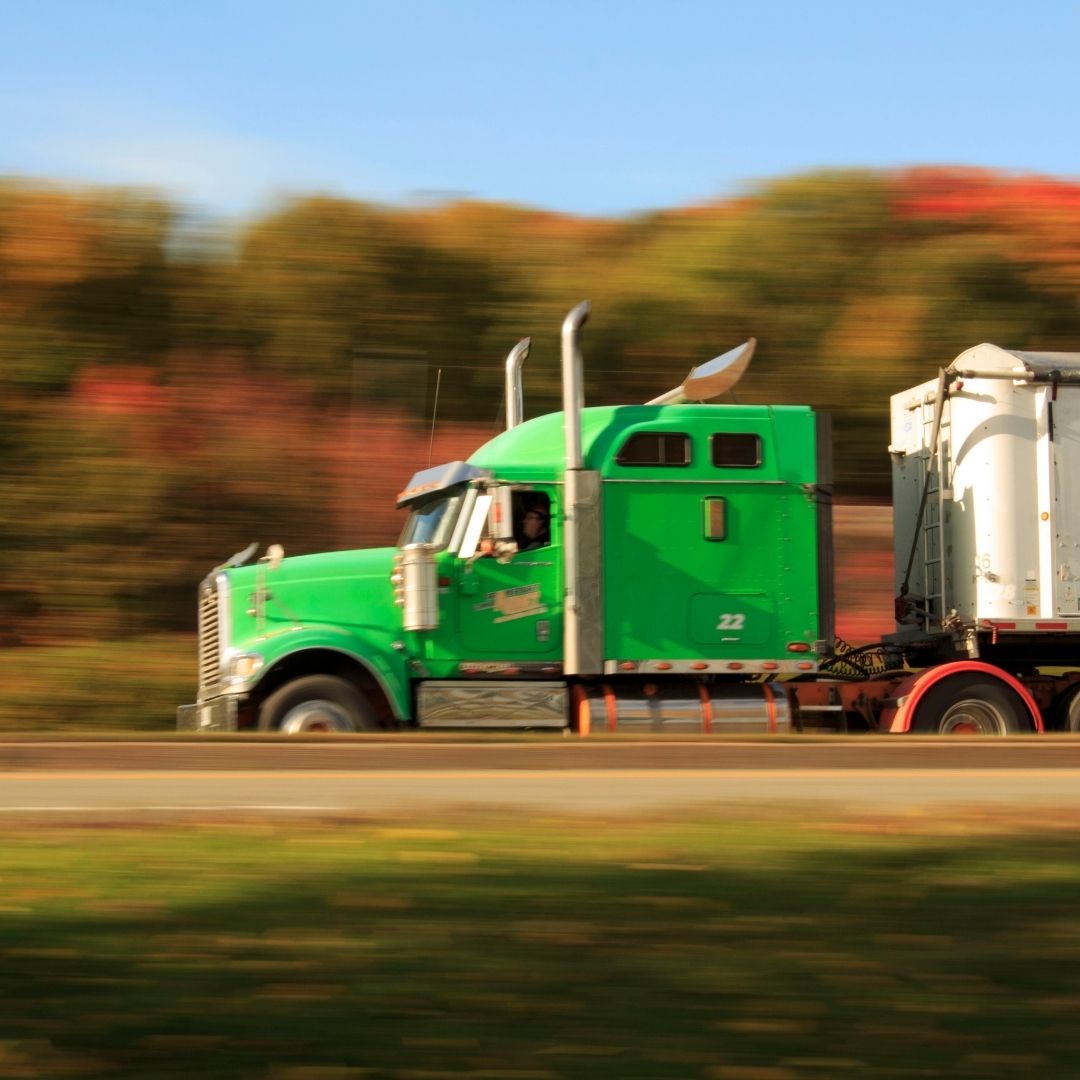 green semi-truck on highway