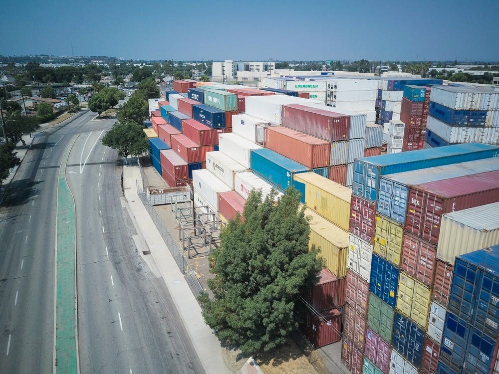Aerial View of a Road Framed by Stacked Containers on One Side